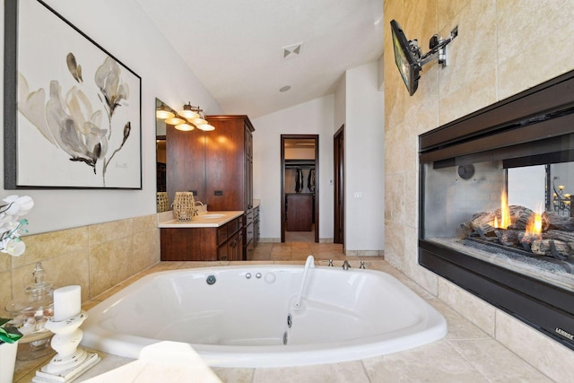 full bathroom with lofted ceiling, a whirlpool tub, and vanity