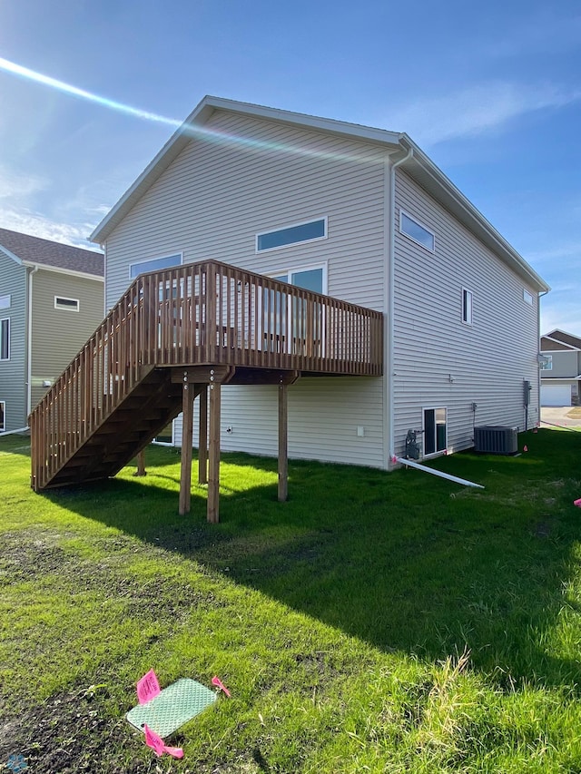 back of property with a yard, central air condition unit, and a deck