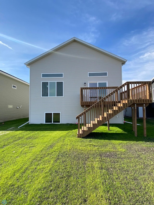 back of house featuring a wooden deck, a lawn, and stairs