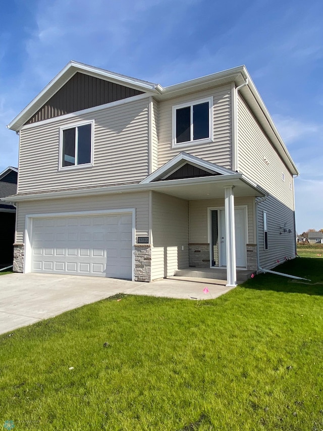 traditional-style home with an attached garage, driveway, a front lawn, and stone siding