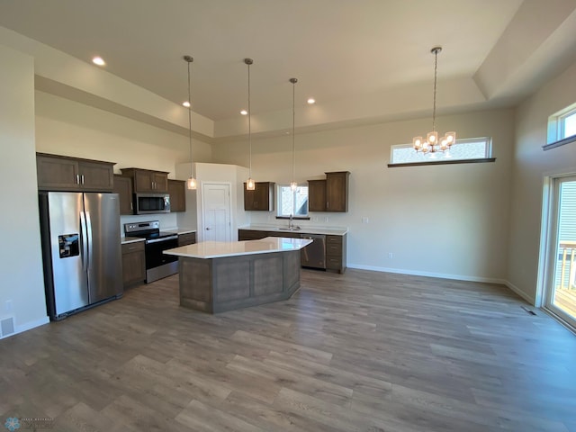 kitchen featuring dark brown cabinets, light countertops, a notable chandelier, and appliances with stainless steel finishes
