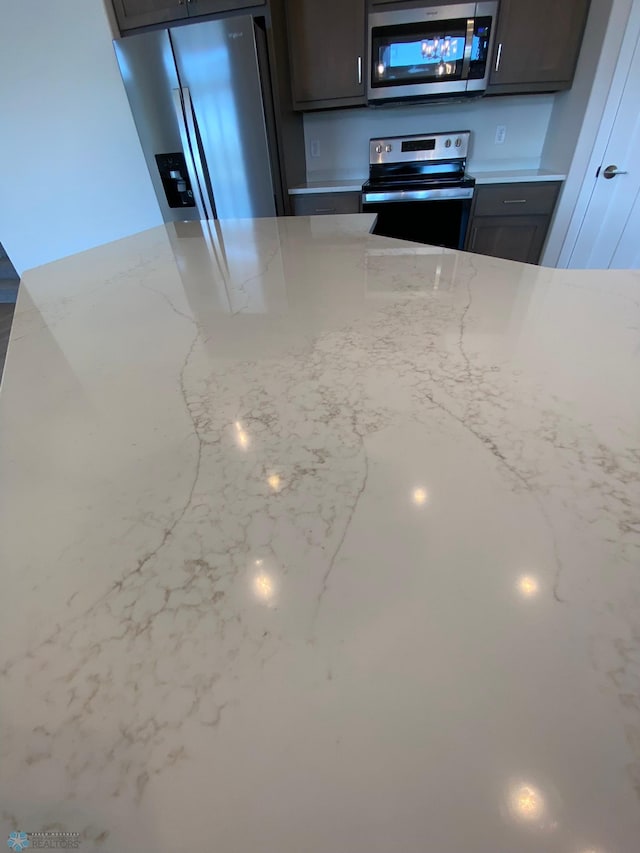 kitchen featuring light stone countertops and stainless steel appliances