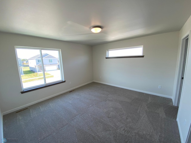carpeted empty room featuring visible vents and baseboards