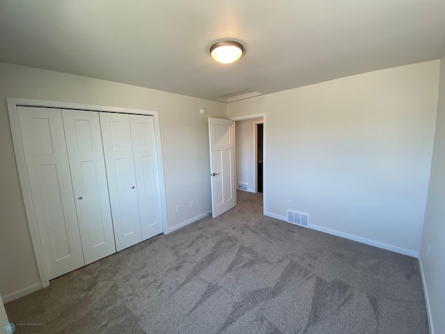 unfurnished bedroom with baseboards, visible vents, a closet, and carpet flooring