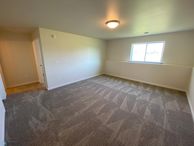 spare room featuring baseboards and carpet
