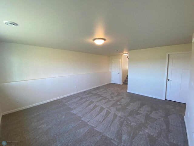 carpeted empty room featuring baseboards