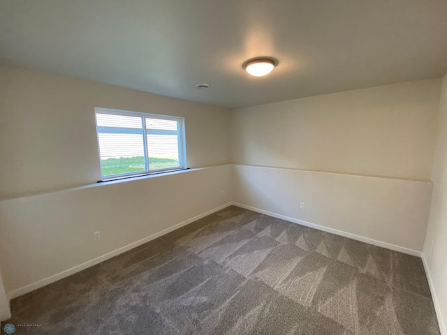 spare room featuring carpet floors and baseboards