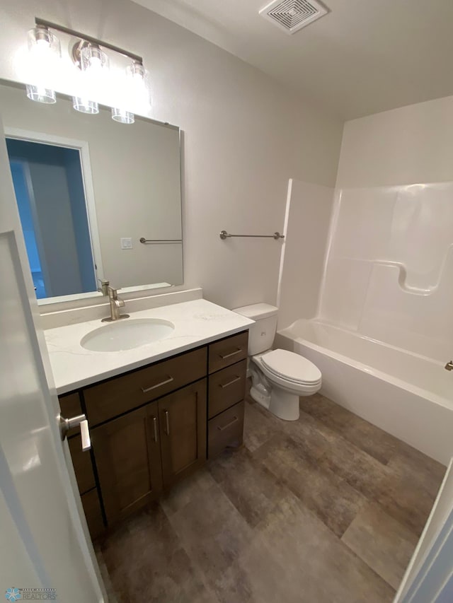bathroom with visible vents, vanity,  shower combination, and toilet