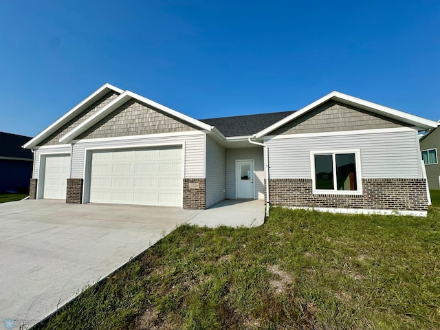 view of front of property featuring a garage, a front yard, concrete driveway, and brick siding