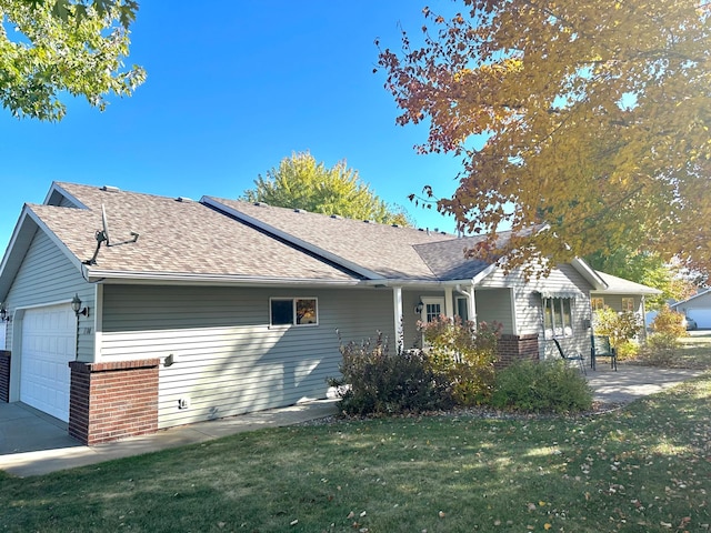 view of side of property with a garage, a lawn, and covered porch