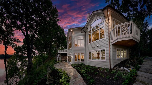 back house at dusk with a balcony