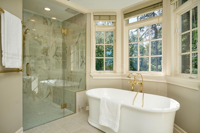 bathroom featuring a healthy amount of sunlight, shower with separate bathtub, and tile patterned flooring