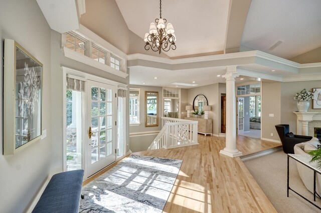 entrance foyer featuring decorative columns, light hardwood / wood-style floors, and a healthy amount of sunlight