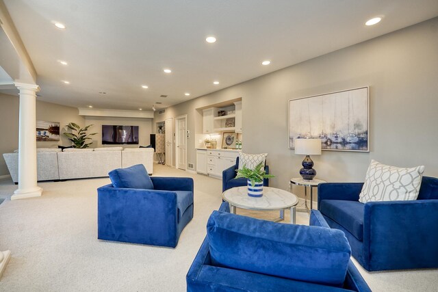 living room featuring light colored carpet and decorative columns