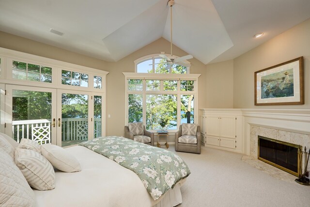 bedroom featuring carpet, lofted ceiling, a premium fireplace, and access to exterior