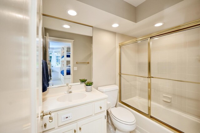 full bathroom featuring vanity, toilet, and combined bath / shower with glass door