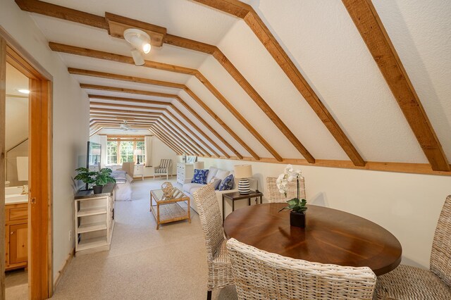 carpeted bedroom with lofted ceiling, ensuite bathroom, and sink