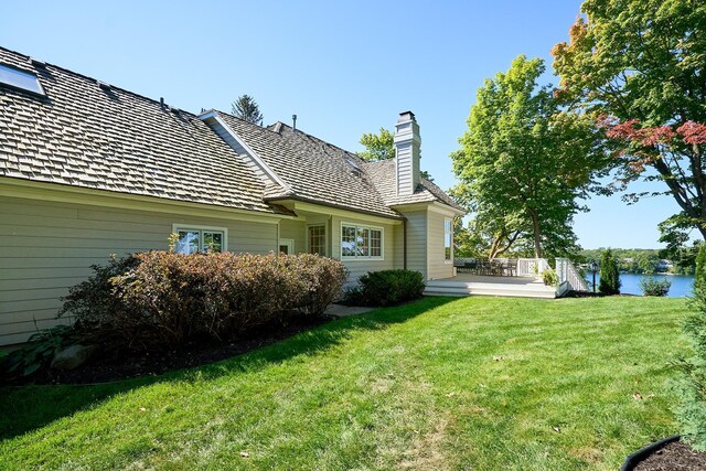 rear view of property with a yard and a water view