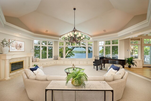 living room featuring an inviting chandelier, ornamental molding, a high end fireplace, and a wealth of natural light