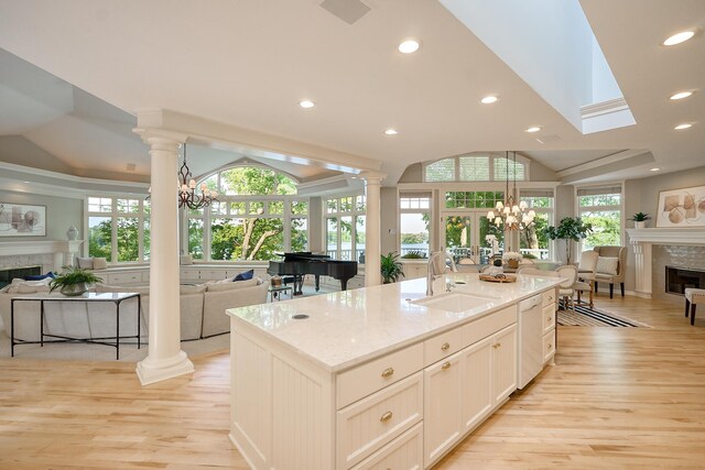 kitchen featuring a chandelier, light stone counters, a healthy amount of sunlight, and sink