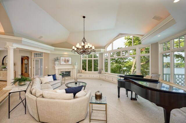 living room featuring vaulted ceiling, an inviting chandelier, light carpet, crown molding, and ornate columns