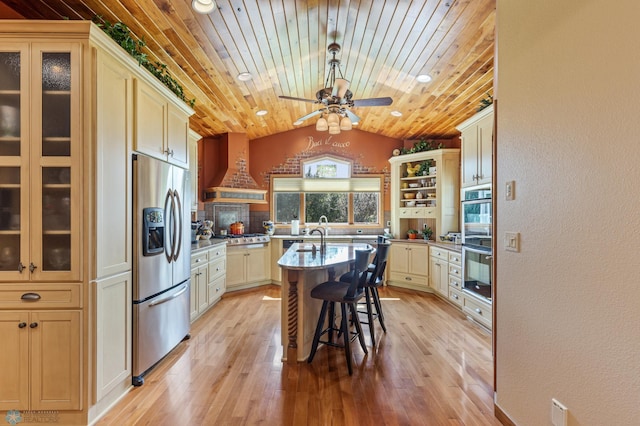 kitchen with wood ceiling, custom range hood, appliances with stainless steel finishes, a breakfast bar, and light wood-type flooring