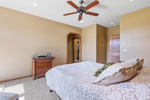 bedroom featuring arched walkways, light colored carpet, baseboards, and recessed lighting