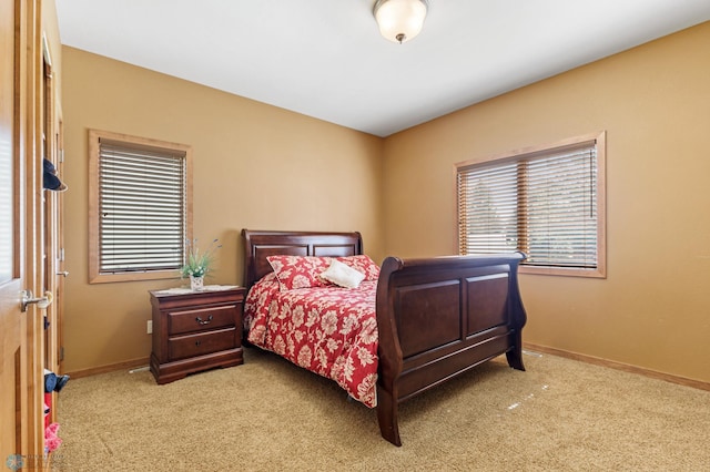 bedroom featuring light colored carpet, multiple windows, and baseboards