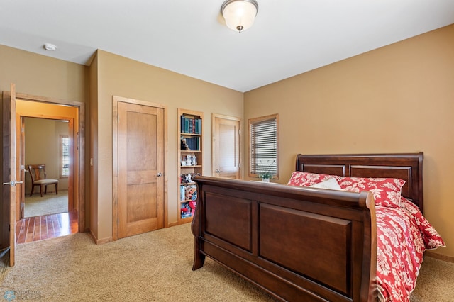 bedroom with light carpet and baseboards