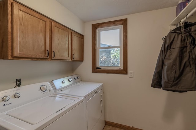 clothes washing area with cabinets and washer and dryer