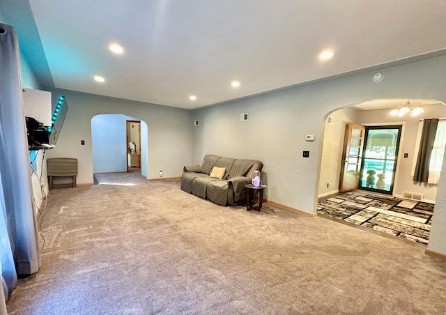 carpeted living room with visible vents, arched walkways, baseboards, and recessed lighting