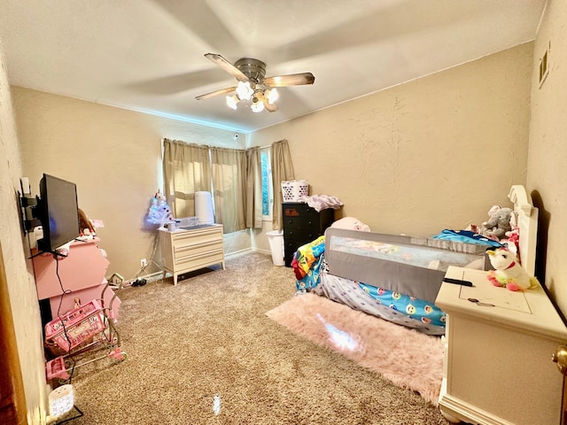 bedroom with ceiling fan, a textured wall, and carpet