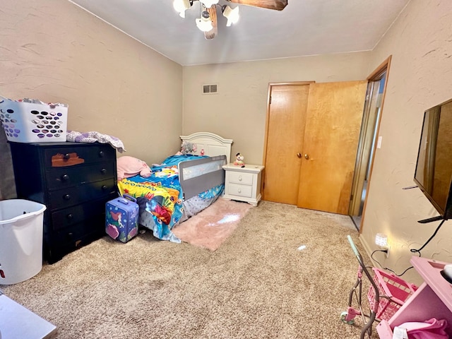 bedroom featuring visible vents, a ceiling fan, a textured wall, carpet floors, and a closet