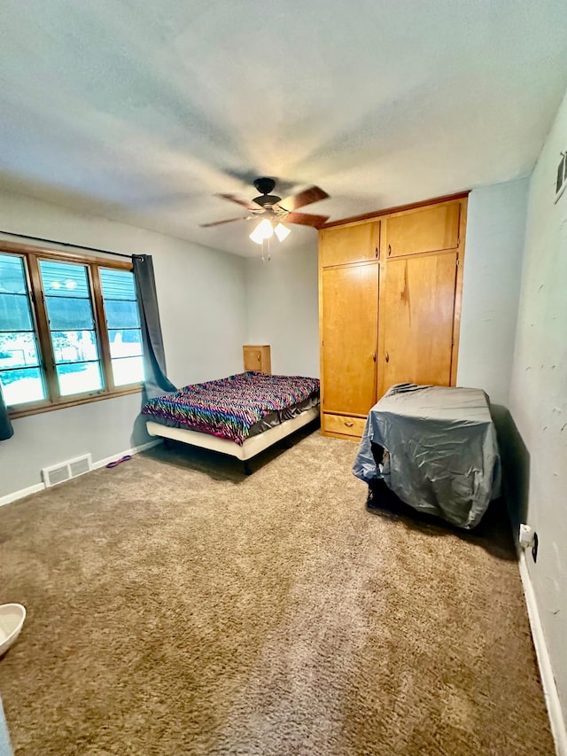 bedroom with baseboards, ceiling fan, visible vents, and carpet flooring