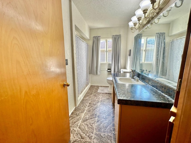 full bathroom featuring toilet, an inviting chandelier, a textured ceiling, vanity, and a shower with curtain