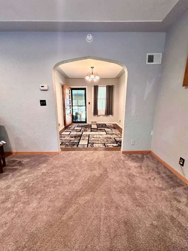 interior space with arched walkways, carpet, visible vents, and a notable chandelier