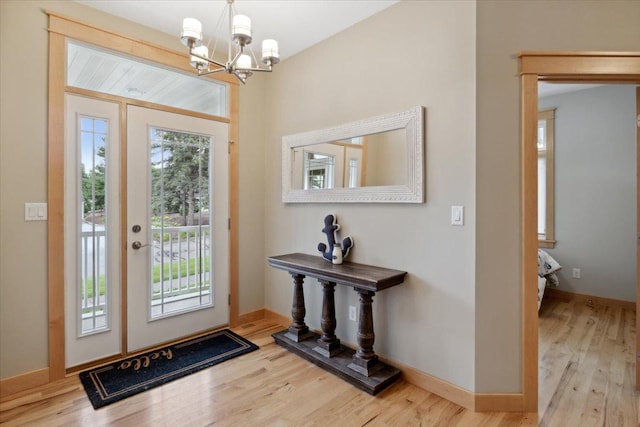 foyer entrance with light hardwood / wood-style flooring, wood ceiling, and a chandelier