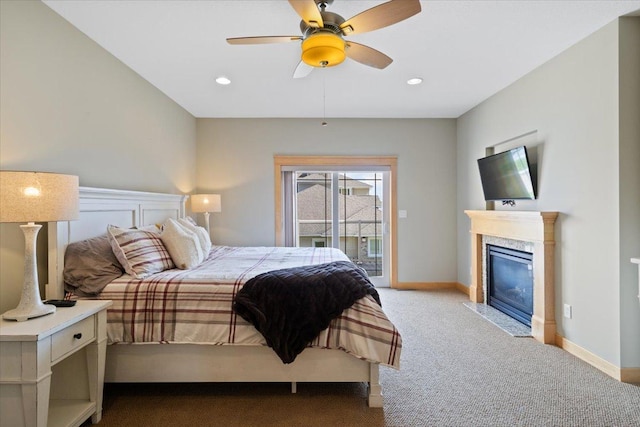 carpeted bedroom featuring access to outside, a premium fireplace, and ceiling fan