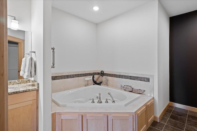 bathroom featuring tile patterned flooring, vanity, and a bathing tub