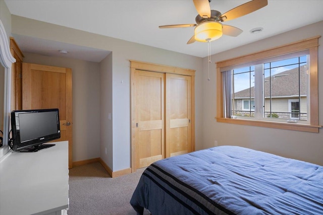 bedroom with light carpet, ceiling fan, and a closet