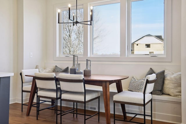 dining room with a notable chandelier, dark wood-type flooring, and a wealth of natural light