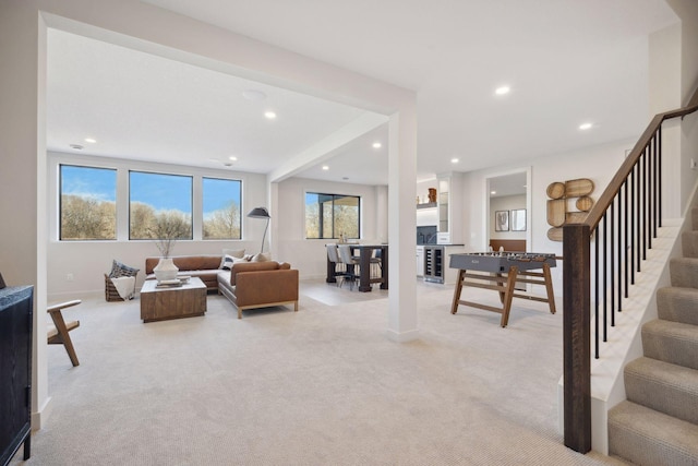 living room with recessed lighting, light colored carpet, baseboards, and stairs