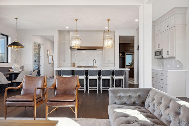 living area with dark wood-style floors and recessed lighting