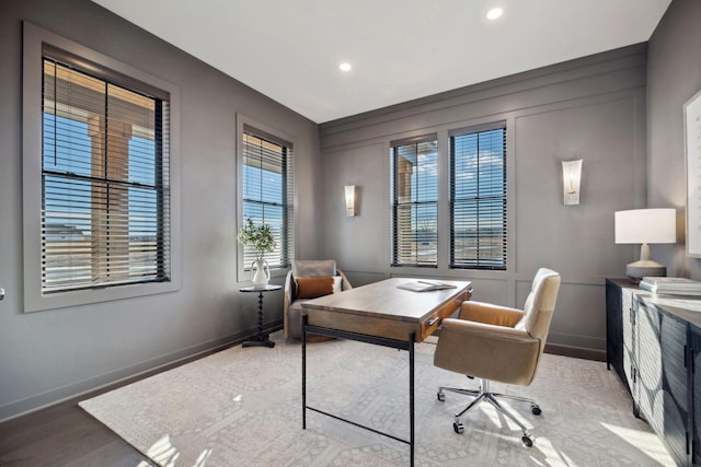 office area with recessed lighting, a decorative wall, baseboards, and wood finished floors