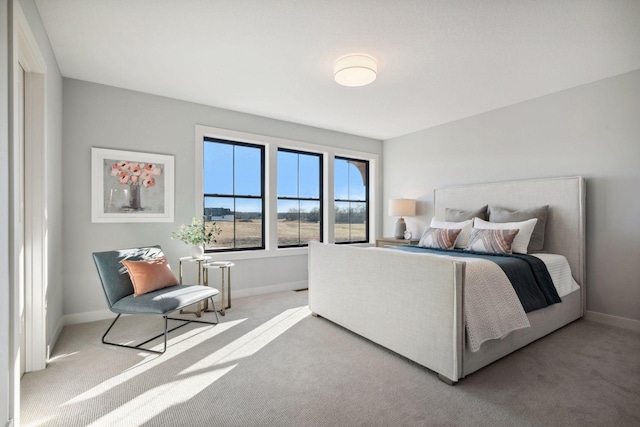 bedroom with baseboards and light colored carpet