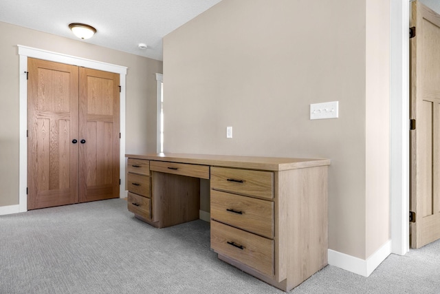 unfurnished office with light colored carpet and built in desk