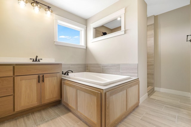 bathroom with vanity and shower with separate bathtub