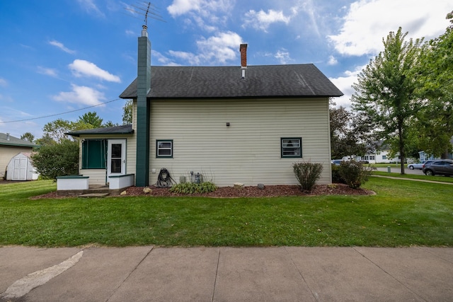 view of side of property with a yard and a storage shed