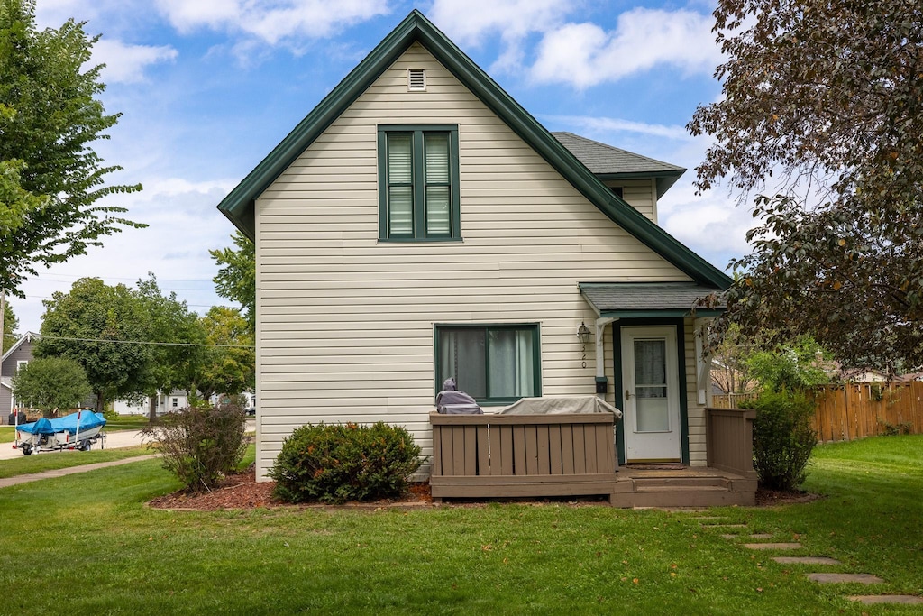 rear view of house featuring a yard and fence