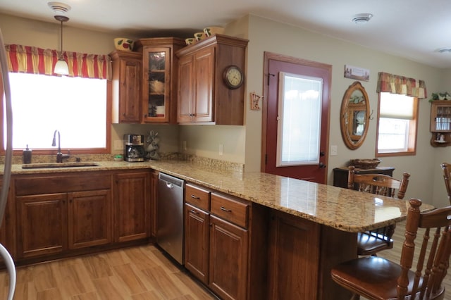 kitchen with dishwasher, sink, a kitchen breakfast bar, and kitchen peninsula